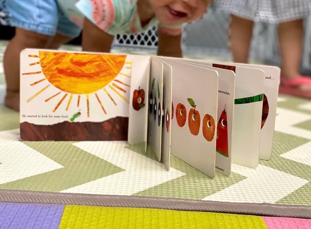 picture of a kid playing in a daycare with coloring books